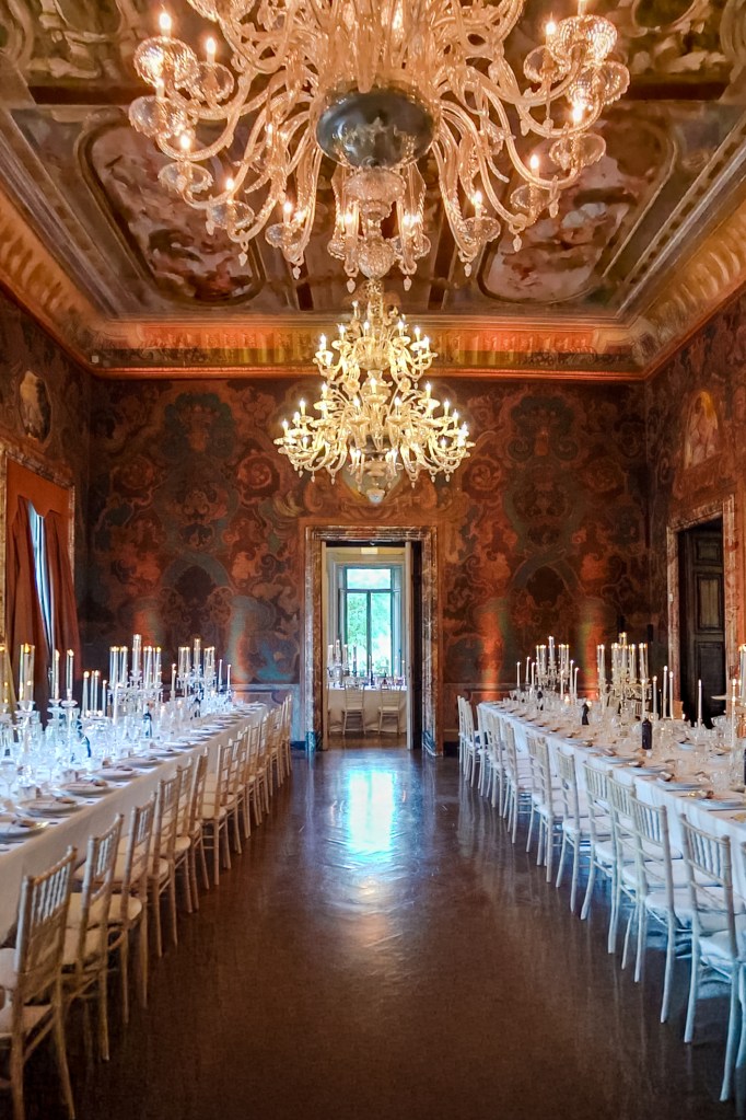 Inside of the Villa Erba hall with two long dinner tables standing parallel of each other