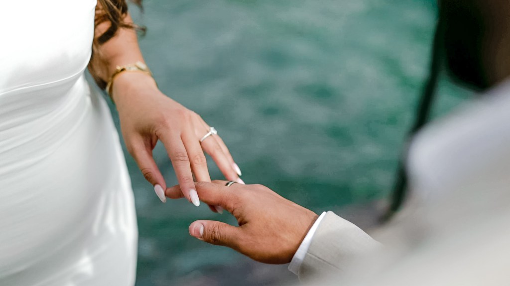 A close up of the newly engaged couple's hands entertwined together