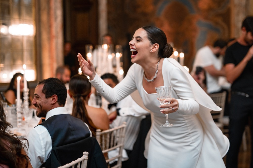 A candid shot of the bride laughing during the wedding dinner speeches
